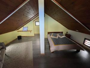 Schlafzimmer im Dachgeschoss mit einem Bett in einem Zimmer in der Unterkunft LES VETYVERS in Grande Ravine