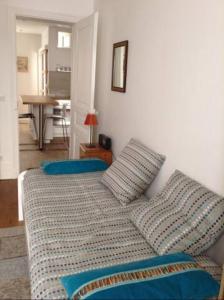 1 dormitorio con 1 cama con sábanas y almohadas azules en 47m2 Calme au cœur de Parîs, en París