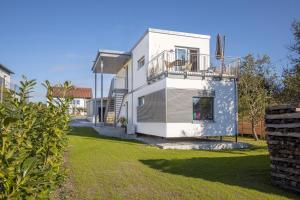 a white house with a balcony and a yard at albspace in Sonnenbühl