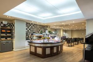 a salon with a bar in the middle of a room at Hotel Cortezo in Madrid