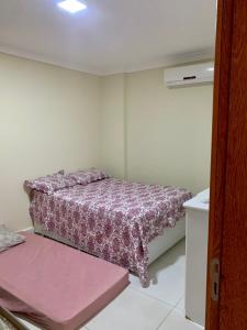 - une petite chambre avec un lit et une couverture violette dans l'établissement Casa temporada com piscina, à Vila Velha