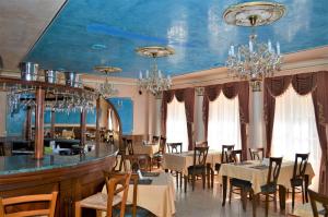 un restaurante con mesas y sillas y techo azul en Hotel Renesance Krasna Kralovna, en Karlovy Vary