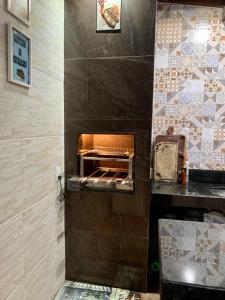 - une cuisine avec un four à pizza dans un mur dans l'établissement Casa temporada com piscina, à Vila Velha