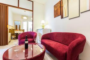 a living room with two chairs and a wine bottle on a table at Forum 2BR apartment in old town in Zadar