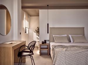 a bedroom with a bed and a desk and a chair at Julieta Villas in Zakynthos