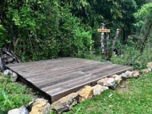 a wooden deck with rocks in the grass at Villa Léovil in Saint-Pompont