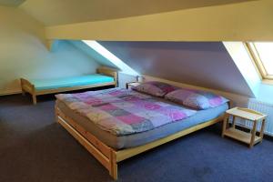 1 dormitorio con 1 cama y un banco en el ático en Penzion Rankl-Sepp, en Stachy