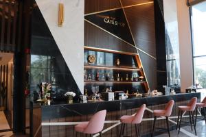 a bar at a restaurant with pink chairs at Rio Hotel Olaya in Riyadh