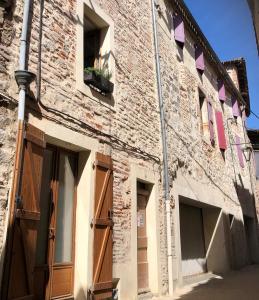 un edificio de ladrillo con puerta y ventana en La Donzelle, en Cahors