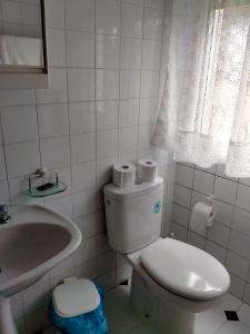 Baño blanco con aseo y lavamanos en Casa da Fontiña, en Seoane