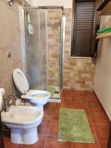 La salle de bains est pourvue de toilettes, d'une douche et d'un lavabo. dans l'établissement Villa Patrizia, à Canicattì
