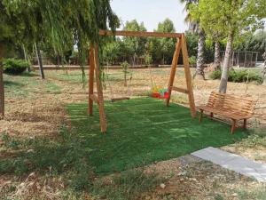 a park with a bench and a swing at Villa Patrizia in Canicattì
