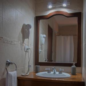 y baño con lavabo, secador de pelo y espejo. en LA AGUADA - Villa de Mar, en Villa Gesell