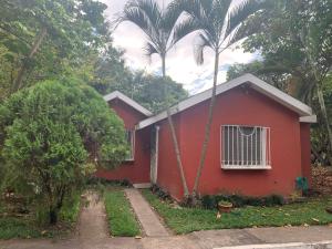 a red house with a palm tree in front of it at Casa a 5 minutos de los parques del IRTRA in Pucá