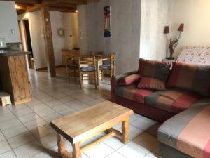 uma sala de estar com um sofá e uma mesa em chez nous em Chilhac