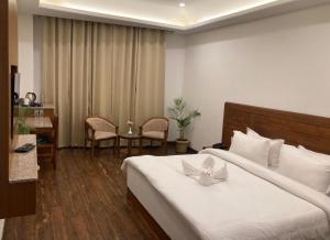 um quarto de hotel com uma cama, uma mesa e cadeiras em Namastasya em Solan