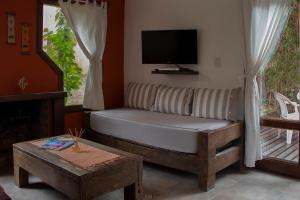a living room with a couch and a tv at LA AGUADA - Villa de Mar in Villa Gesell