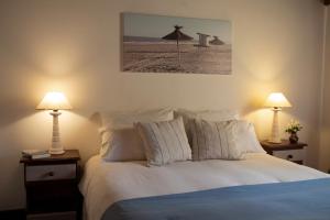 a bedroom with a bed and two lamps on tables at LA AGUADA - Villa de Mar in Villa Gesell