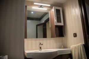 ein Badezimmer mit Waschbecken und Spiegel in der Unterkunft Хотел България Петрич in Petrich + 12 Fotos