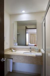 La salle de bains est pourvue d'un lavabo et d'un grand miroir. dans l'établissement Costa Club Punta Arena - Todo Incluido, à Puerto Vallarta