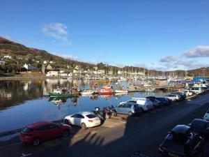 a bunch of cars parked next to a marina with boats at The waterfront in Tarbert