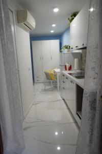 a kitchen with white cabinets and a table with a yellow chair at Giata home in Naples