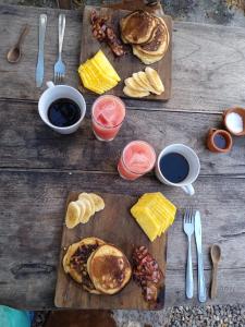 a wooden table topped with pancakes and other breakfast foods at Hostal Colonial de Santander in Girón