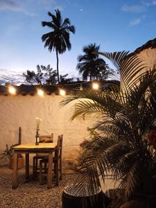 einen Tisch und Stühle auf einer Terrasse mit einer Palme in der Unterkunft Hostal Colonial de Santander in Girón