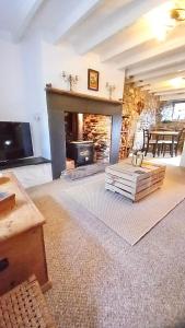 a living room with a fireplace and a table at Merrion Cottage Penmachno Betws y Coed Conwy in Penmachno