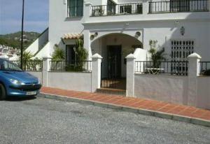 een blauwe auto geparkeerd voor een wit huis bij Casa Galesa in Nerja