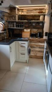 a kitchen with white cabinets and wooden walls at Merrion Cottage Penmachno Betws y Coed Conwy in Penmachno