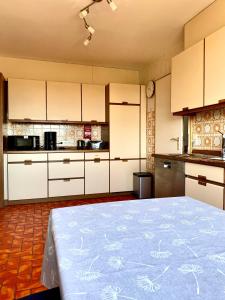 a kitchen with white cabinets and a large bed at Ferienwohnung Waldhütter in Schwarzenbach an der Saale