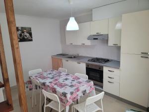 a kitchen with a table and chairs and a kitchen with white cabinets at Alojamento Rosa in Nazaré