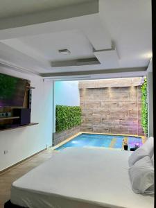 a bedroom with a swimming pool outside a window at Hotel River Suite in Leticia