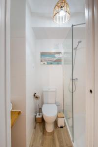 a bathroom with a toilet and a glass shower at Ocean House Alentejo in Porto Covo +30 photos