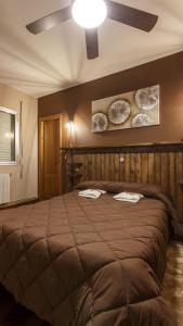 a bedroom with a large bed with a ceiling fan at H Rural Chamouco in Bóveda