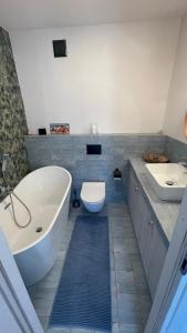 a bathroom with a tub and a toilet and a sink at Apartament Mechelinki, wysoki standard. in Pierwoszyno