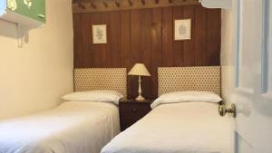 two beds sitting next to each other in a room at Wood House Cottage in Cockermouth