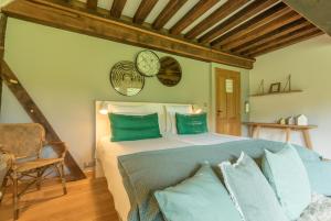 Maisons d'hôtes - Domaine Le Coq Enchanté في Cambremer: غرفة نوم بسرير كبير ومخدات خضراء