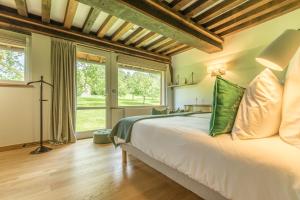 康布勒梅尔Maisons d'hôtes - Domaine Le Coq Enchanté的卧室里有一张白色的大床，上面放着绿色的枕头 更多37张照片
