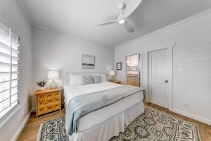 una camera da letto bianca con un letto e un ventilatore a soffitto di The Tipsy Trout a Rockport