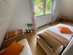 een slaapkamer met 2 bedden en een raam bij Haus Adler - Komplettes Ferienhaus am Badesee in Erzgrube