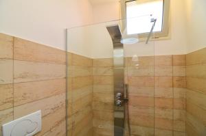 una doccia con porta in vetro in bagno di Boomerang Residence a Torre Colimena a Torre Colimena