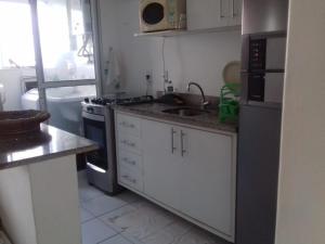 a small kitchen with a sink and a stove at Piatã apartamento com Clube in Salvador