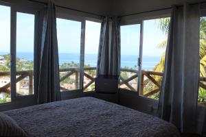 a bedroom with a bed and a view of the ocean at Posada Las Graditas in Sayulita