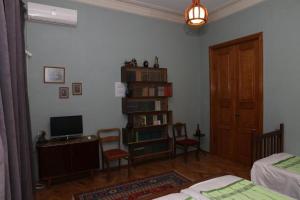 a room with a bedroom with a bed and a television at Sun Guest House in Kutaisi