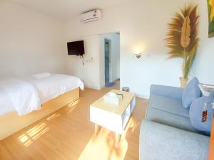 a room with a couch and a bed and a tv at Abams Gili Air in Gili Air