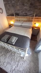 a large bed with two pillows on it in a room at Merrion Cottage Penmachno Betws y Coed Conwy in Penmachno