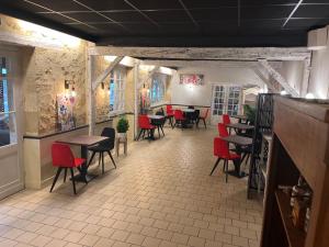 a restaurant with red chairs and tables in a room at Hôtel du Château - Beynac et Cazenac in Beynac-et-Cazenac