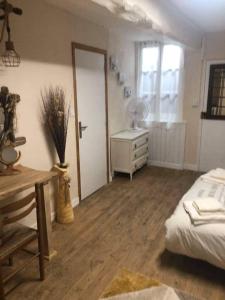 a bedroom with a bed and a desk and a door at Maison de Rêve in Notre-Dame-du-Touchet